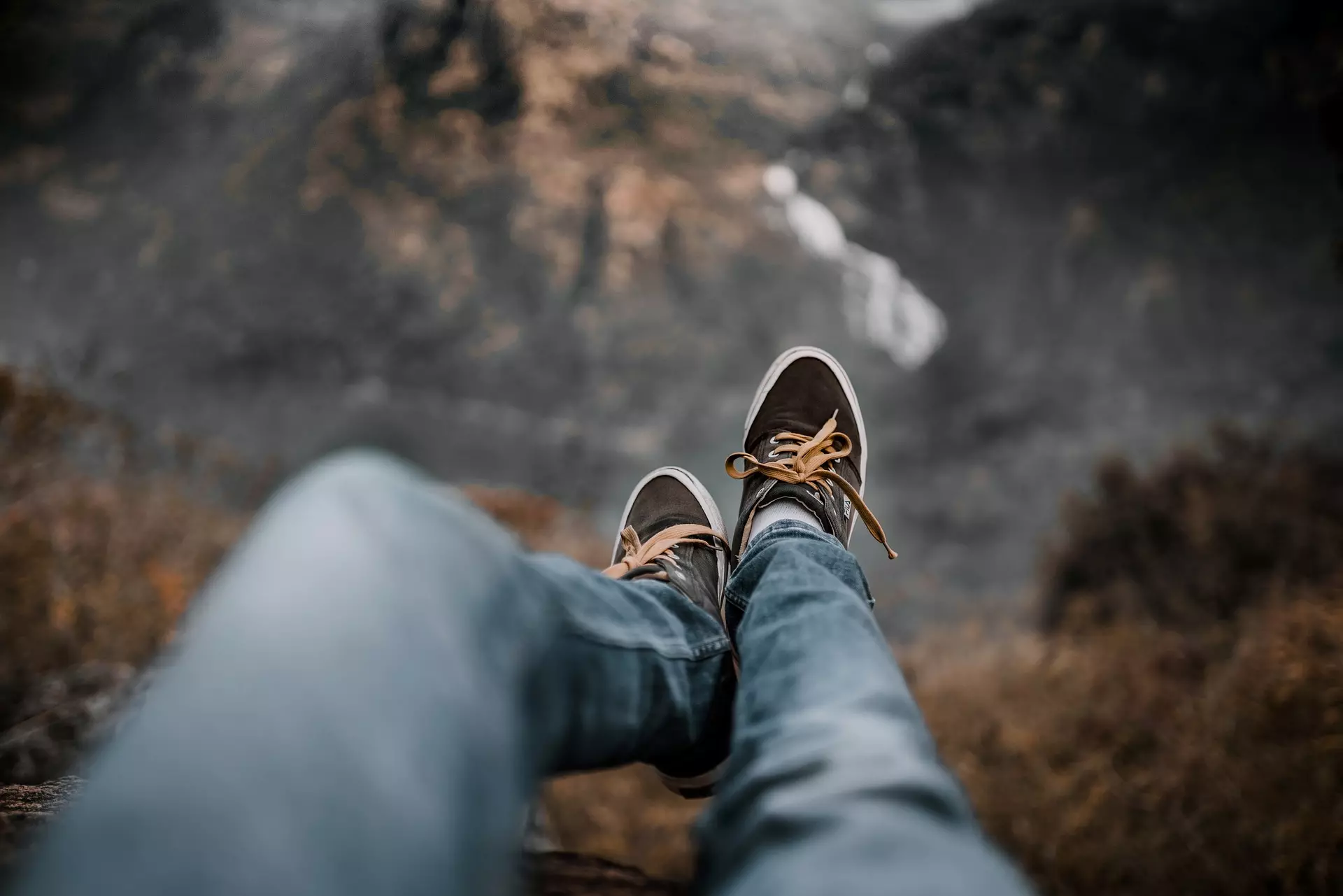 View from the perspective of a person sitting on a cliff edge, looking past their shoes